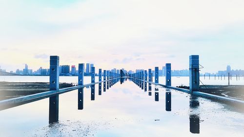 City at waterfront against cloudy sky