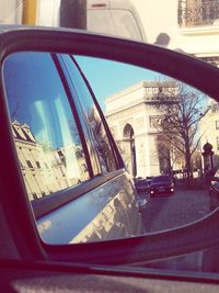 Reflection of buildings on side-view mirror