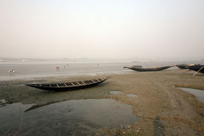 Boats of fishermen stranded in the mud at low tide on the river matla near canning town, india