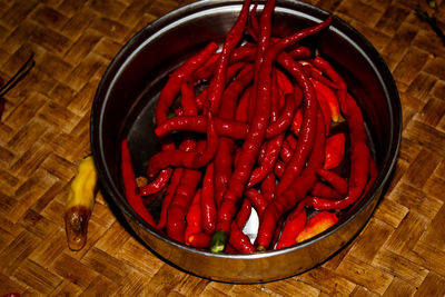 High angle view of red chili peppers in bowl on table