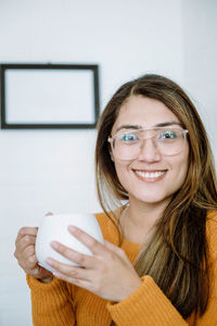 Mexican young woman drinks from a white cup with natural pose