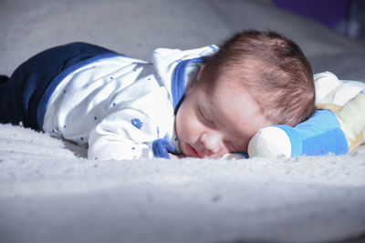 Close-up of cute baby boy sleeping on bed