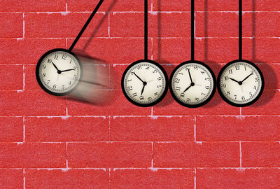 Close-up of clock on red wall