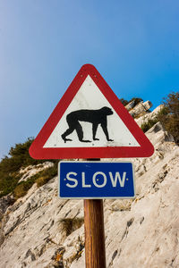 Close-up of road sign against clear blue sky