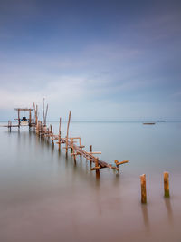 Pier over lake against sky during sunset