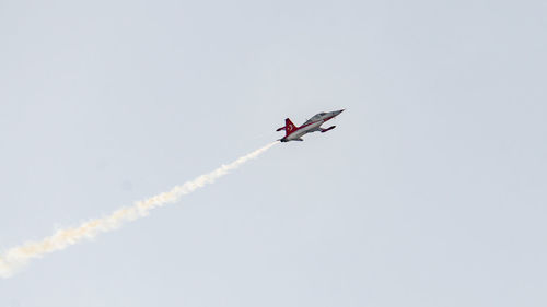 Low angle view of airplane flying against sky