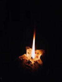 Close-up of burning candle in the dark