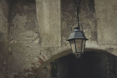 Low angle view of lantern hanging on wall