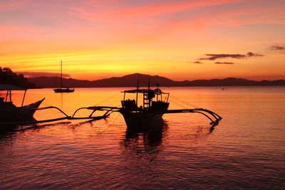 Silhouette boat in sea against sky during sunset