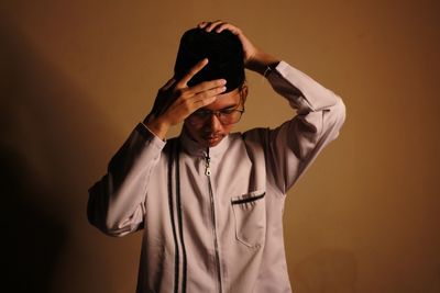 Young man standing against wall