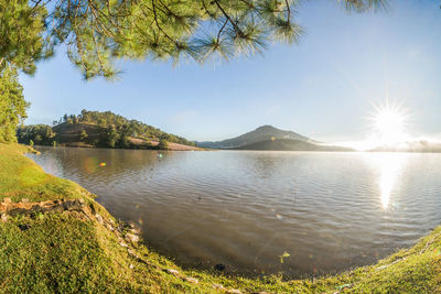 Scenic view of lake against sky on sunny day