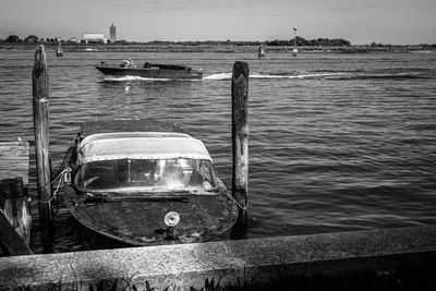 Boat moored on sea against sky