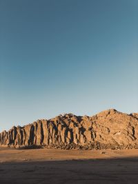 Scenic view of desert against clear blue sky