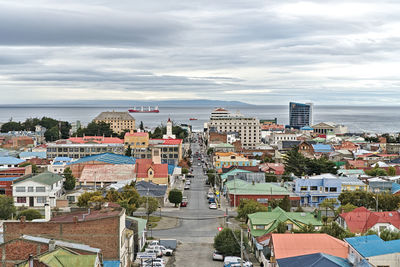 High angle view of townscape by sea against sky