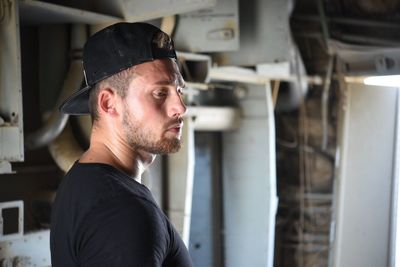 Thoughtful man in cap looking away indoors