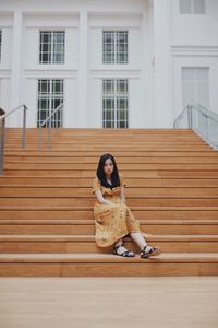 Portrait of woman sitting on staircase