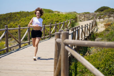 Rear view of woman walking on footbridge