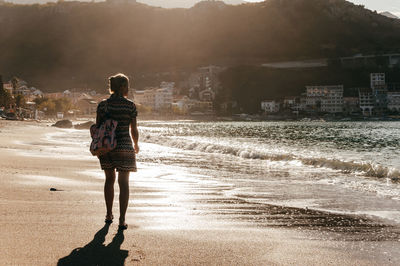 Rear view of woman walking on beach