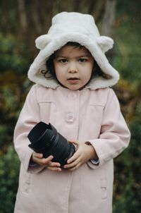 Portrait of baby girl standing against tree