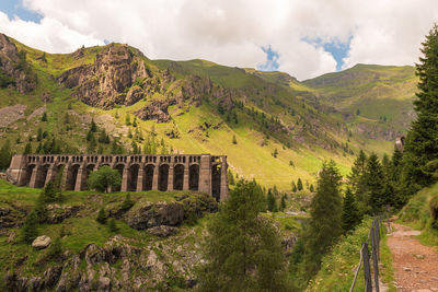 Scenic view of mountain and dam against cloudy sky