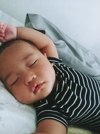 Portrait of cute baby boy lying on bed at home