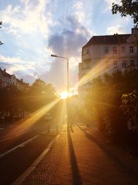 Road passing through city during sunset