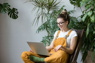 Smiling woman using laptop at home