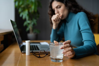 Sick female employee coughing and suffering from flu, taking antipyretic medications at workplace