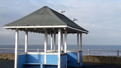 Gazebo by sea against sky