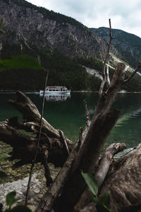 Scenic view of lake against mountain and a boat full of tourists