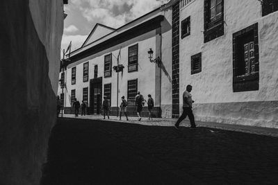 People walking on street amidst buildings in city