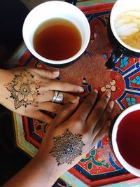 Directly above shot of woman holding coffee cup on table
