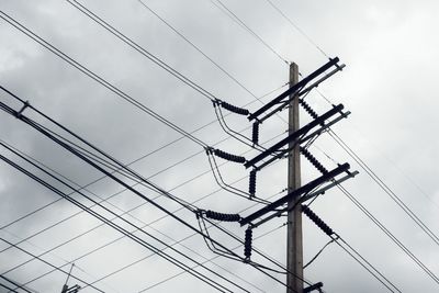 Low angle view of electricity pylon against sky