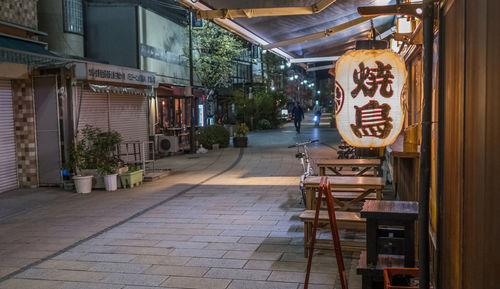 Empty footpath amidst buildings in city