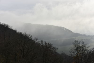 Scenic view of lake by mountains against sky