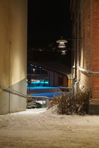 Illuminated street in city during winter at night