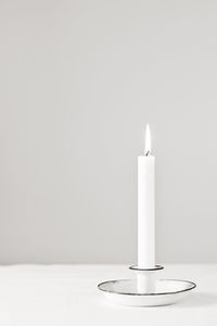 Close-up of lit candle on table