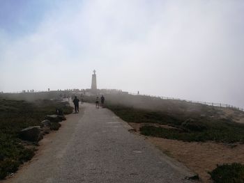 View of people on footpath against sky