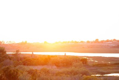 Scenic view of land against clear sky during sunset