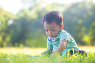 Cute boy playing on grass at park