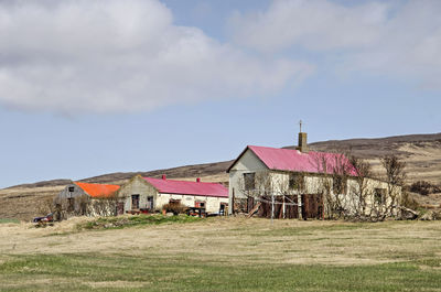 Group of traditional farmhouses and barns on a grassy slope