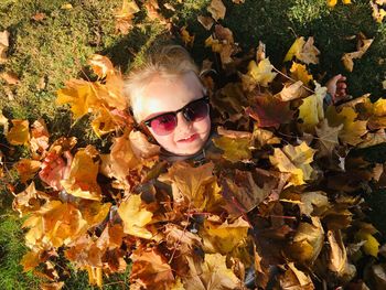 Portrait of man with sunglasses on leaves during autumn