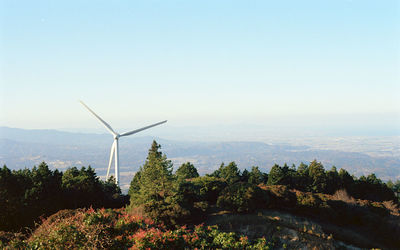 Wind turbines on land against sky