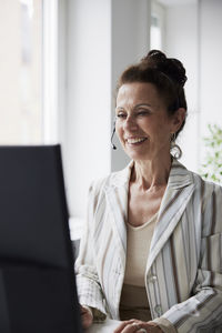 Smiling mature woman working in call center