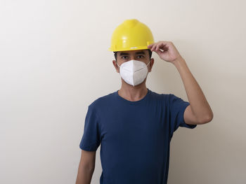 Man wearing hat standing against white background