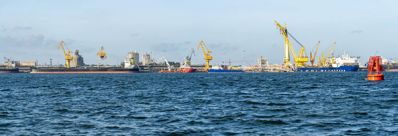 Commercial dock by sea against sky