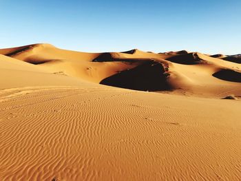 Scenic view of desert against clear blue sky