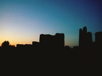 Low angle view of silhouette buildings against sky during sunset