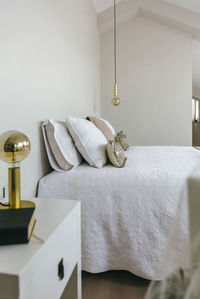 Mannequin on bed against white wall at home
