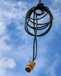 Low angle view of cable hanging against sky